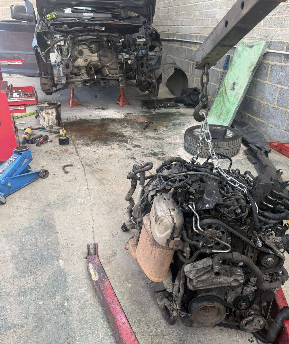 Engine removed from a car on the workshop floor in Kent